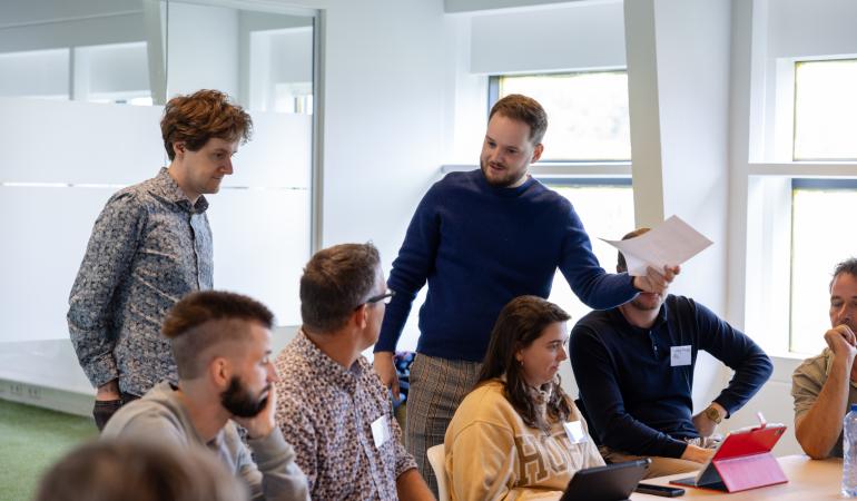 Afbeelding van twee mannen die in een deelsessie uitleg geven aan een groep mensen