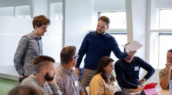 Afbeelding van twee mannen die in een deelsessie uitleg geven aan een groep mensen